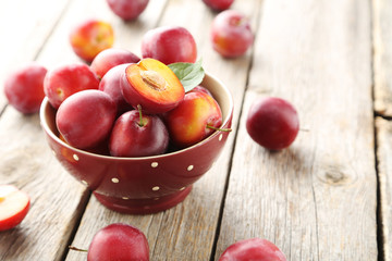 Fresh plums on a grey wooden table