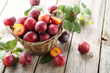 Fresh plums on a grey wooden table