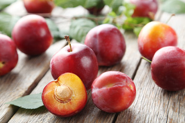Fresh plums on a grey wooden table