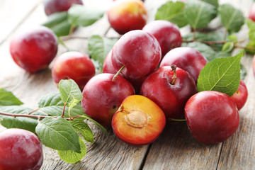 Fresh plums on a grey wooden table