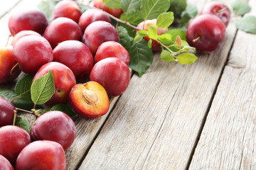 Fresh plums on a grey wooden table