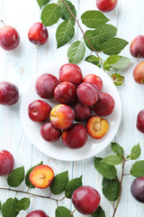 Fresh plums on a white wooden table