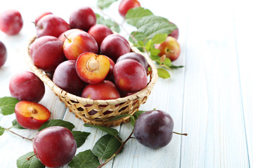 Naklejka na ściany i meble Fresh plums on a white wooden table