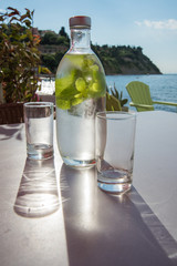 Obraz premium Bottle of cold mint water with two glasses on a table