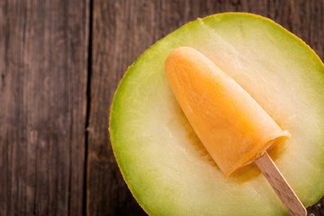 homemade popsicle with melon on wooden background