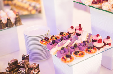 Delicious and tasty dessert table with cupcakes shots at reception closeup