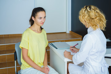 Fototapeta premium Blond female doctor talking to patient in the hospital