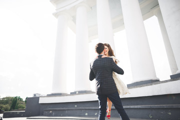 Beautiful couple, bride and groom posing near big white column