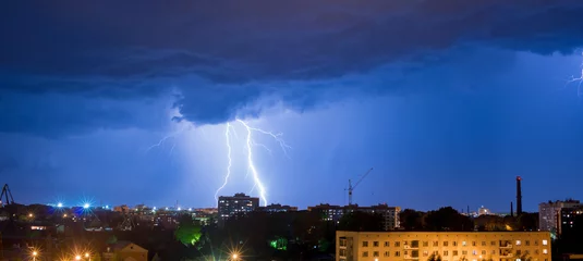 Foto auf Acrylglas Sturm Nachtgewitter über den Gebäuden
