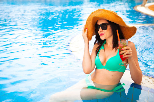 Beautiful brunette woman wearing a hat and sunglasses, enjoying