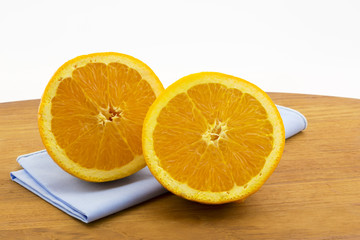 Sliced orange halves on blue naptkin and wood board