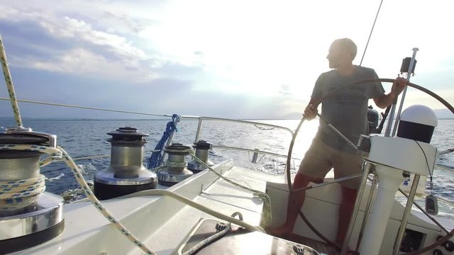 Man On Steering Wheel Navigating Sail Boat