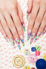 Beautiful female hands with original design manicure on the background of the buttons.