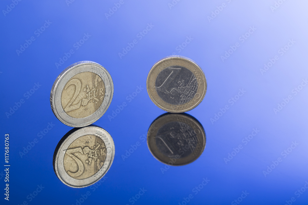 Wall mural Closeup of two and one Euro coins on blue background with nice reflection