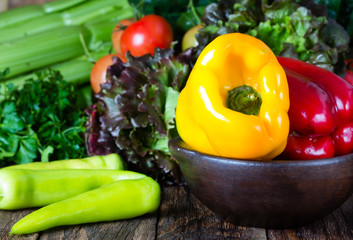 Red and yelow bell pepper in clay bowl