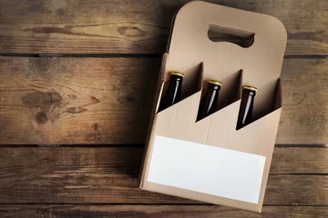 Poster Paper beer package  on wooden background © Africa Studio