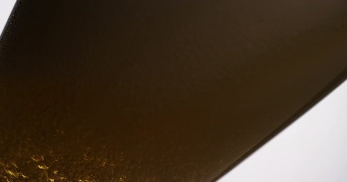 4K Beer being poured into a tilted glass, in slow motion