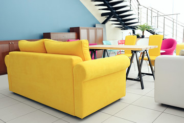 Stylish yellow couch in interior