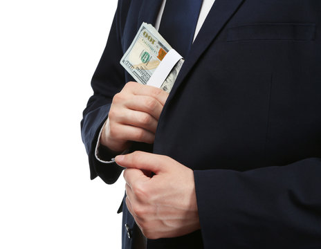 Businessman putting banknotes in suit pocket. Corruption concept