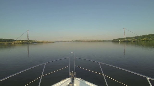 speed motor boat floats on the river to the suspension bridge, suspension bridge over the river,
