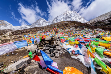 Prayer flags on snow mountains at Yading, China.