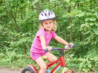 Obraz premium Happy child riding a bike in outdoor.