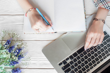 Fashionable business woman working with notebook. Top view on female student hands in cool...