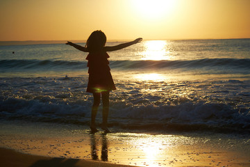 Fototapeta premium girl playing on the beach at sunset