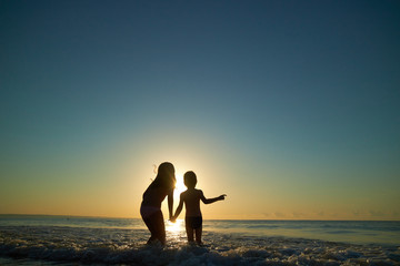 Fototapeta premium boy and girl on the sea at sunset
