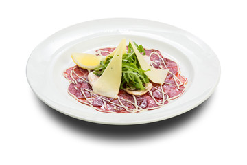 beef carpaccio with mushrooms, parmesan cheese and arugula on a white plate and a white background