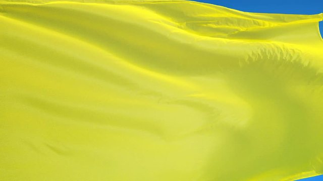 Bright yellow flag waving in slow motion against blue sky, seamlessly looped, close up, isolated on alpha channel with black and white luminance matte, perfect for film, news, digital composition