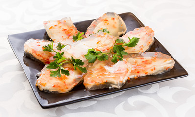 Aspic from meat with carrots. On a black plate and white background