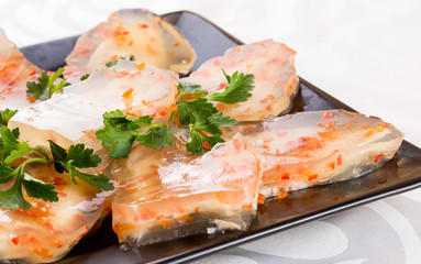 Aspic from meat with carrots. On a black plate