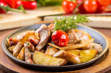 Assorted meat in a pan with potatoes