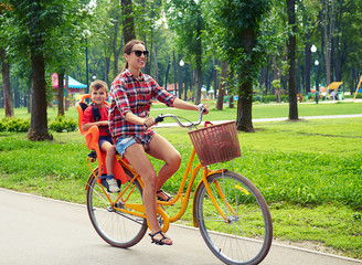 Obraz premium Young active mother and son having fun during a bicycle ride