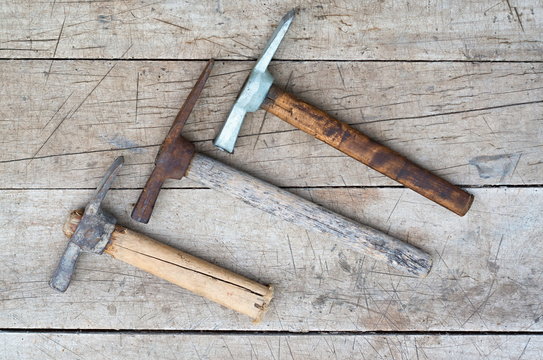 three old pickaxes on wooden background close-up
