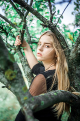 Girl in jeans outdoors. The girl near a tree.