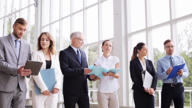 business people walking along office building 12