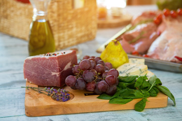 Raw meat and grapes. Pear and green herb. Piece of beef for steak. Ingredients for special dish.