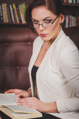 attractive business woman in a business suit with glasses sittin