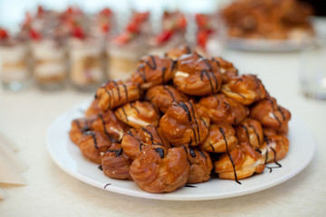 Eclairs covered with chocolate lie on the white plate