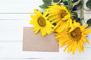 Background with blank card and bouquet of sunflowers on a white