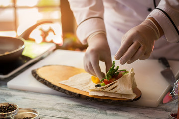 Hands touching cut vegetables. Pita bread and green onion. Experienced chef cooks food. Breakfast for a gourmet.