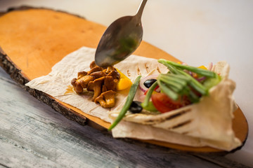 Spoon touches cooked mushrooms. Pita bread with vegetables. Delicious grilled chanterelles. How to cook dietary dish.