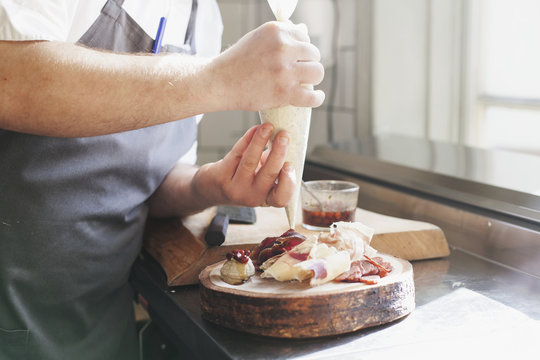 Midsection of chef using icing bag in kitchen