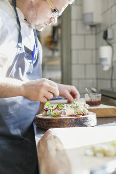 Chef preparing dish at counter in kitchen