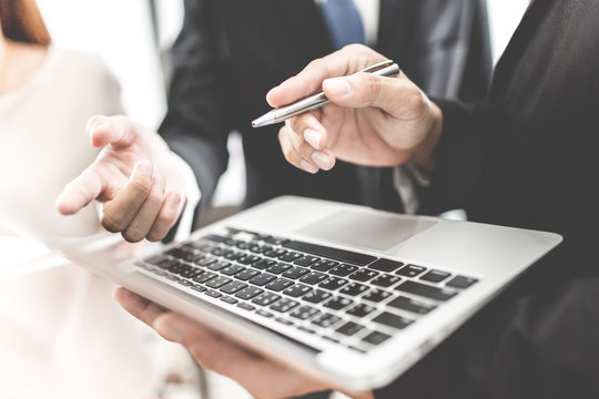 A business team of three sitting in office and planning work