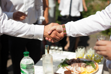 Men shake their hands over a dinner table