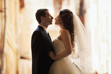Bride and groom admire each other standing in the alley