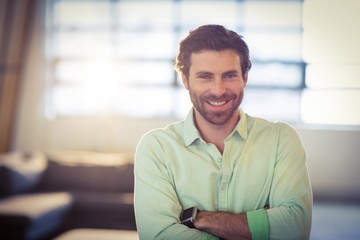 Naklejka premium Portrait of male business executive smiling with arms crossed